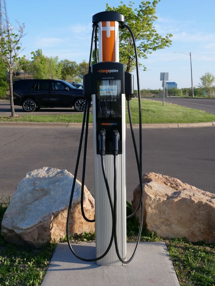Electric vehicle charging station in urban area emphasizing eco-friendly transport.